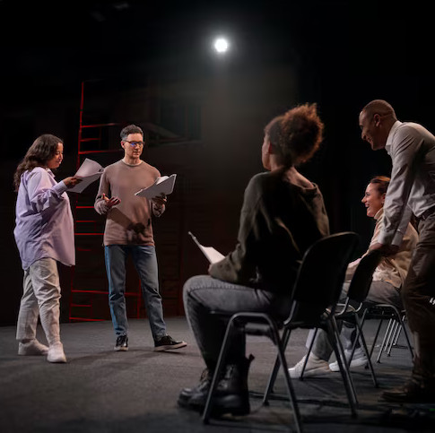 Actors rehearsing in a dark theater